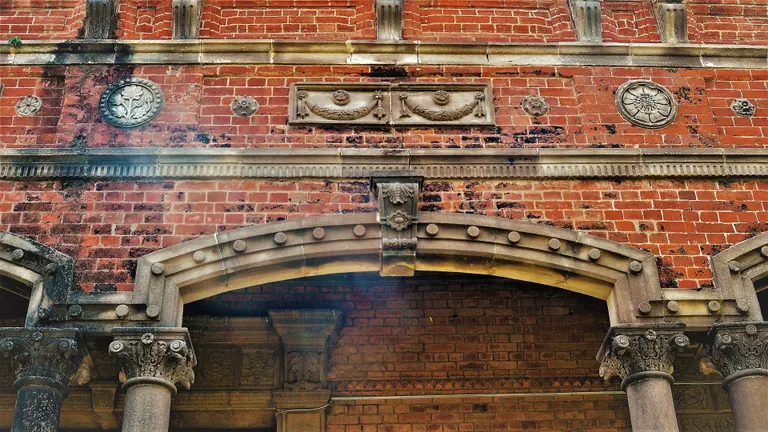 Red brick facade of the Amar Mahal palace in Jammu with arched windows and carved stonework