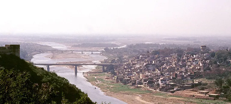 Jammu city spread along the Tawi river with bridges crossing it, seen from a hillside