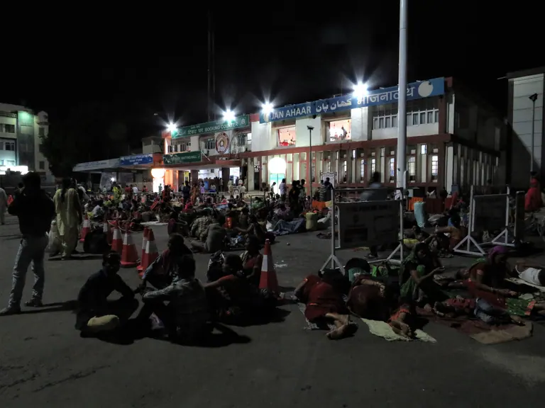 Forecourt of Jammu Tawi railway station at night with travellers resting outside
