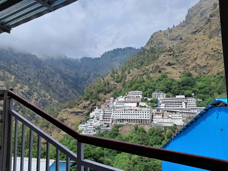 The Mata Vaishno Devi Bhawan complex on the slopes of the Trikuta hills, seen from a viewing railing