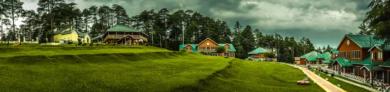 Wide panorama of grassy slopes and conifer forest at Patnitop