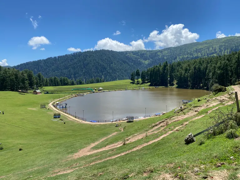 A small lake in the cup-shaped meadow at Sanasar ringed by conifer forest