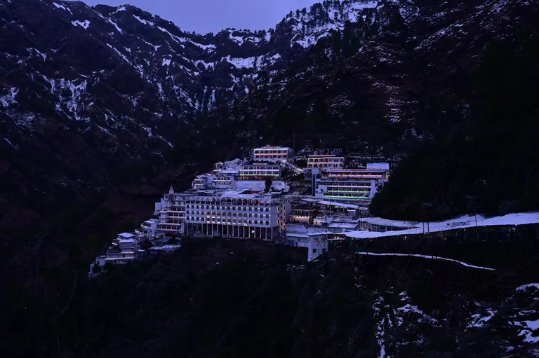 The Vaishno Devi Bhawan on the Trikuta mountain with snow-covered ridges behind it
