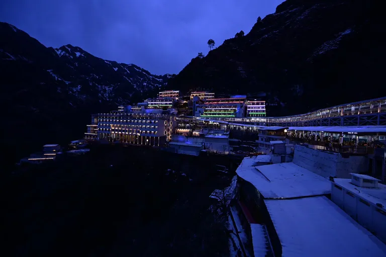 The Vaishno Devi Bhawan and the covered track at dusk, with snow on the walkway and hills