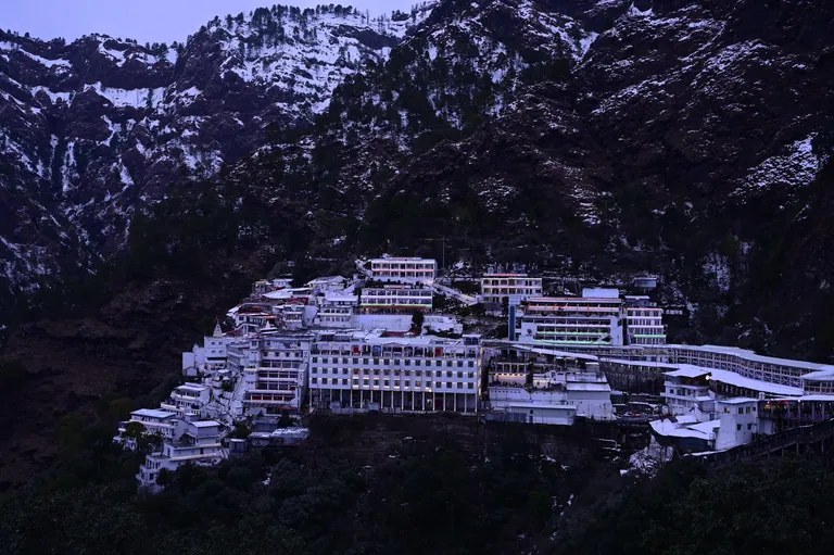 The Mata Vaishno Devi Bhawan complex below snow-dusted mountain slopes in winter
